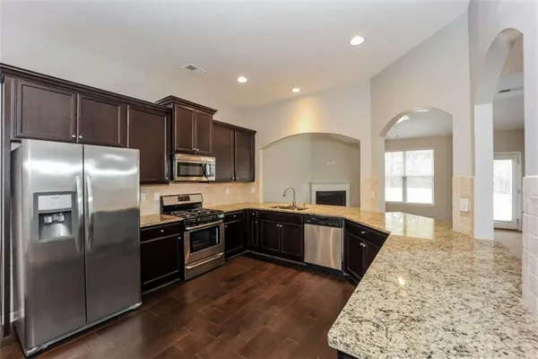 a kitchen with granite countertop stainless steel appliances and wooden cabinets
