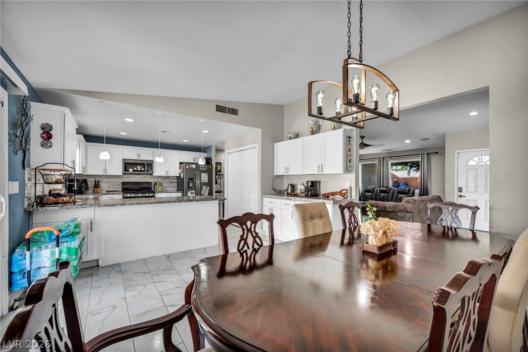 5882 Rio Tinto Way Las Vegas, NV 89110 - Photo 25 of 56 This spacious kitchen and dining area features granite countertops and stainless steel appliances.