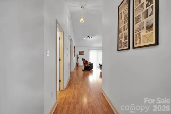 a view of a hallway with wooden floor and furniture