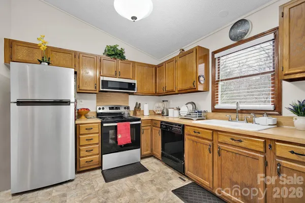 a kitchen with stainless steel appliances granite countertop a refrigerator and a sink
