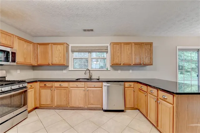 a kitchen with stainless steel appliances granite countertop a sink and cabinets