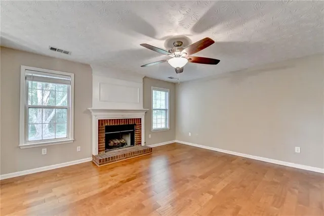 an empty room with windows and fireplace
