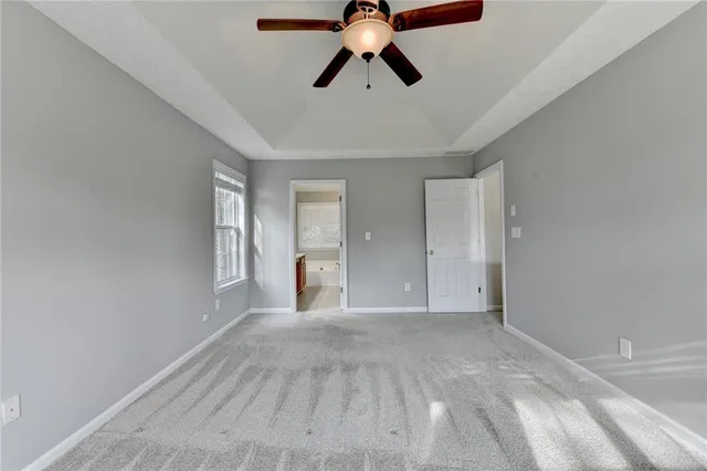 a view of empty room with window and chandelier fan