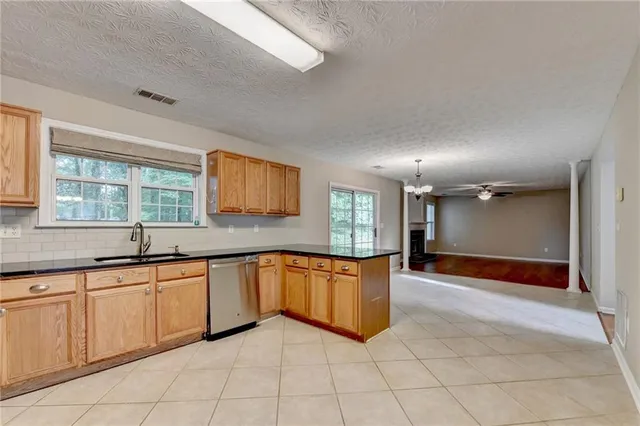 a large kitchen with stainless steel appliances granite countertop a sink and white cabinets