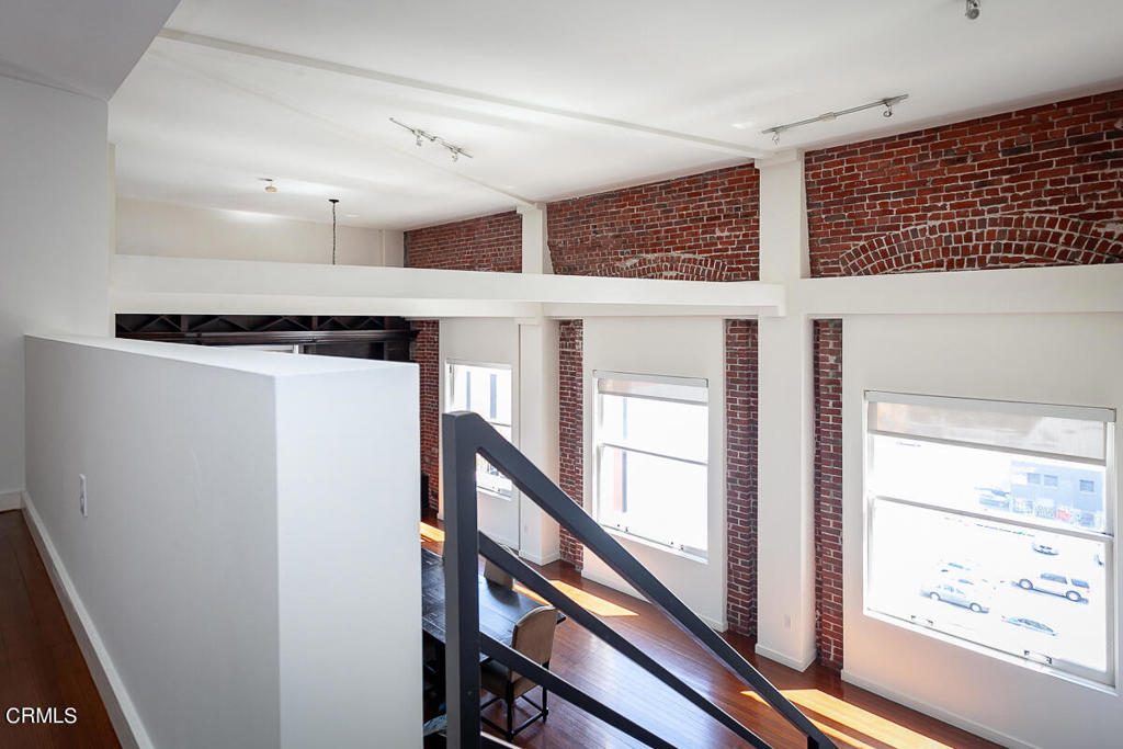 257 South Spring Street, Unit PHE Los Angeles, CA 90012 - Photo 23 of 32 a view of a hallway with wooden floor and staircase