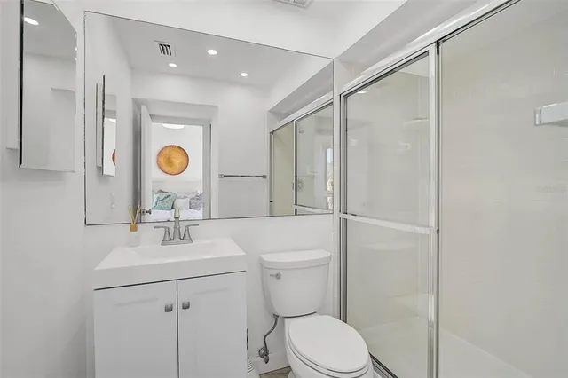 a large white kitchen with granite countertop a stove a sink a dining table and chairs