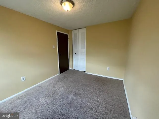 an empty room with a fireplace and windows