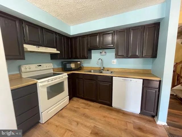 a kitchen with a sink a stove and cabinets