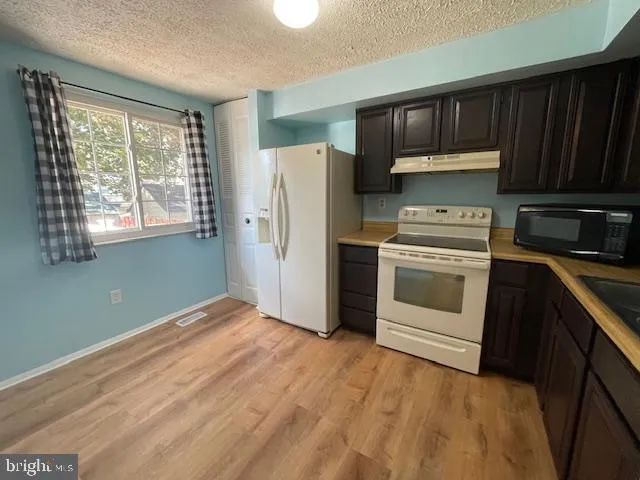 a kitchen with a stove a refrigerator and a sink