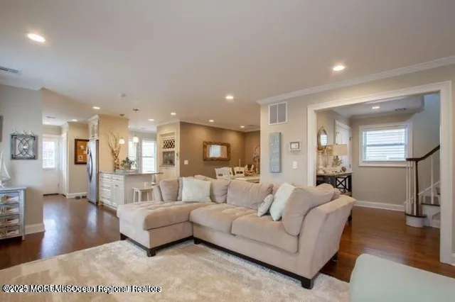 a living room with furniture and a wooden floor