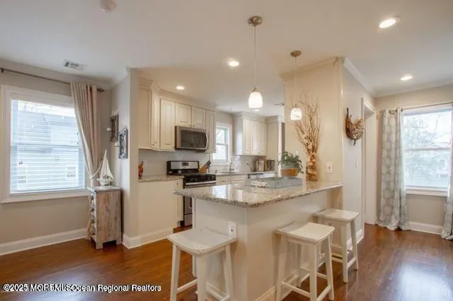 a kitchen with stainless steel appliances kitchen island granite countertop a sink and cabinets