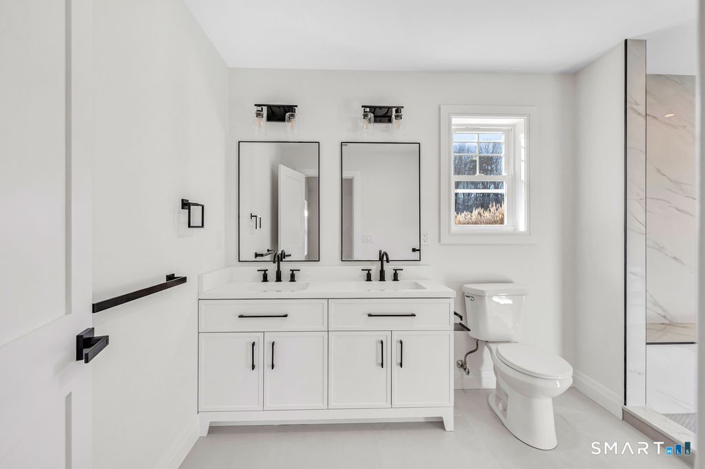 100 Tashua Road Trumbull, CT 06611 - Photo 17 of 29 a bathroom with a double vanity sink a toilet and a mirror