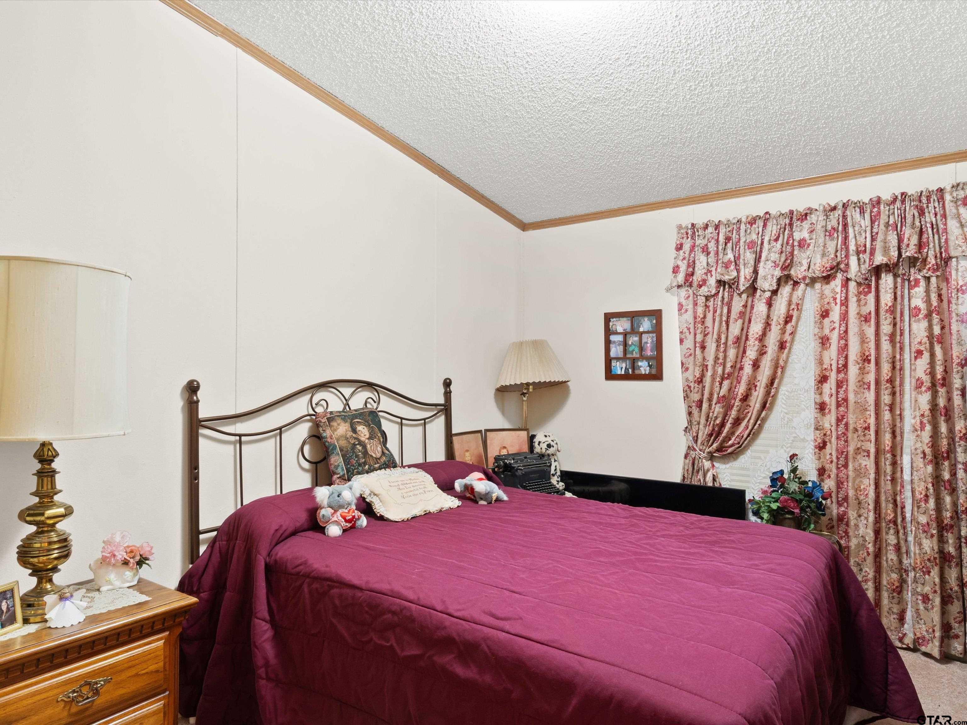 2811 Medlin Road Gilmer, TX 75645 - Photo 21 of 30 a bedroom with a bed and a dresser