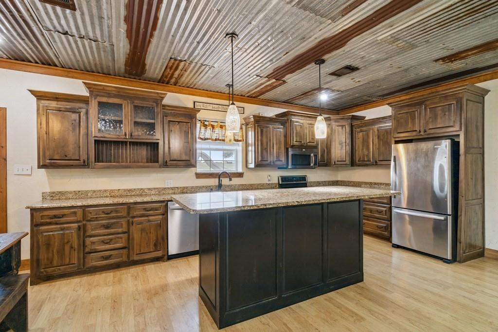 800 County Road 2807 Mabank, TX 75147 - Photo 11 of 40 a kitchen with stainless steel appliances granite countertop wooden cabinets a sink and dishwasher