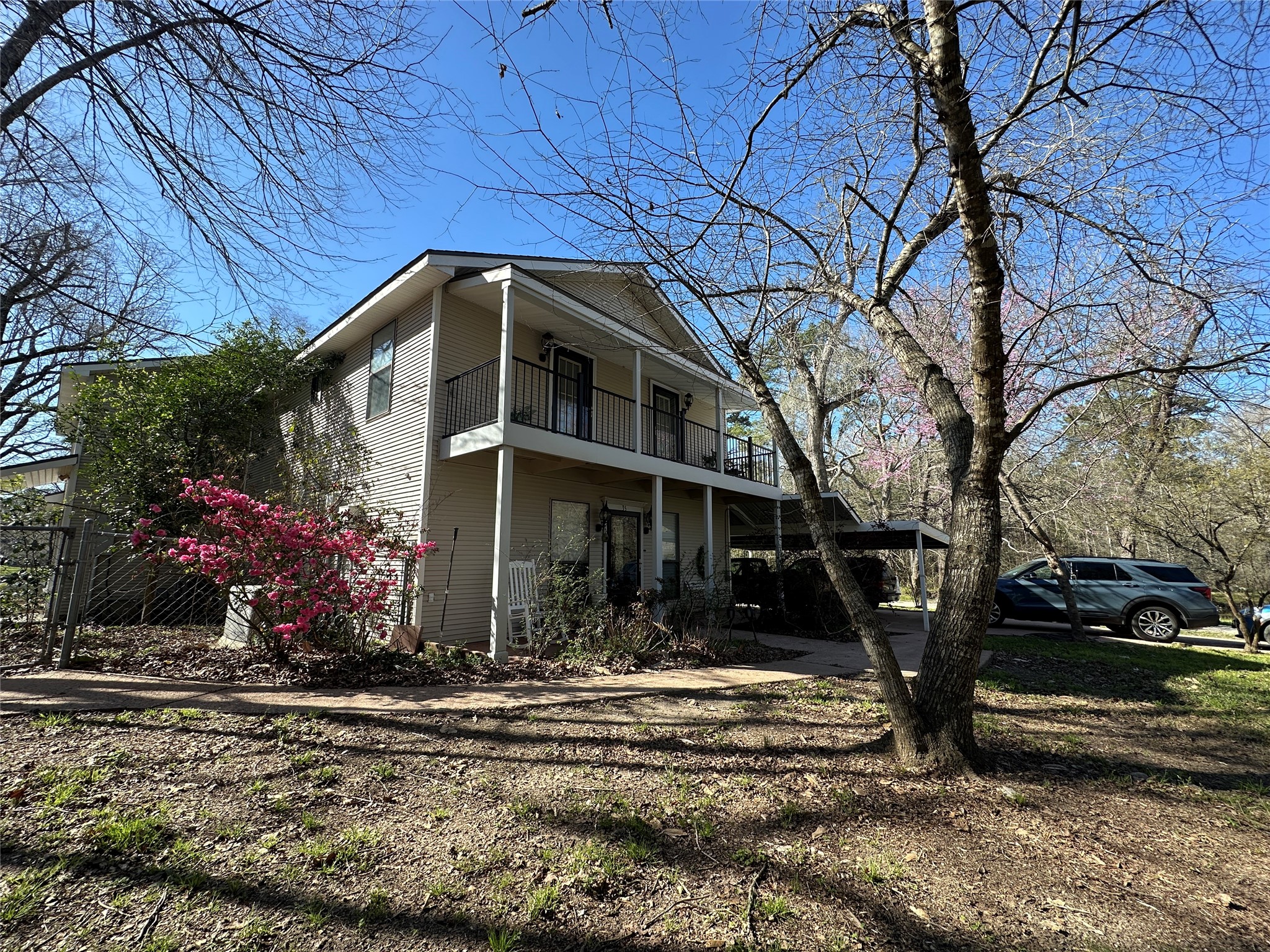 35 Susan Drive Cleveland, TX 77327 - Photo 28 of 33 Charming two-story home with a spacious balcony and covered porch. Surrounded by mature trees and vibrant landscaping, offering a serene, natural setting. A carport provides convenient parking.