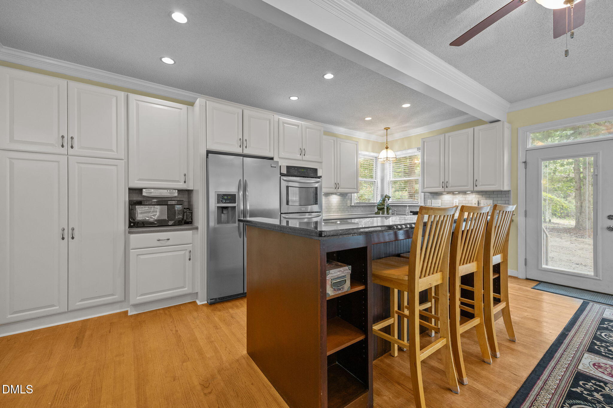 8641 Buffaloe Road Knightdale, NC 27545 - Photo 9 of 52 a kitchen with stainless steel appliances granite countertop a refrigerator a microwave oven a sink with island and chairs