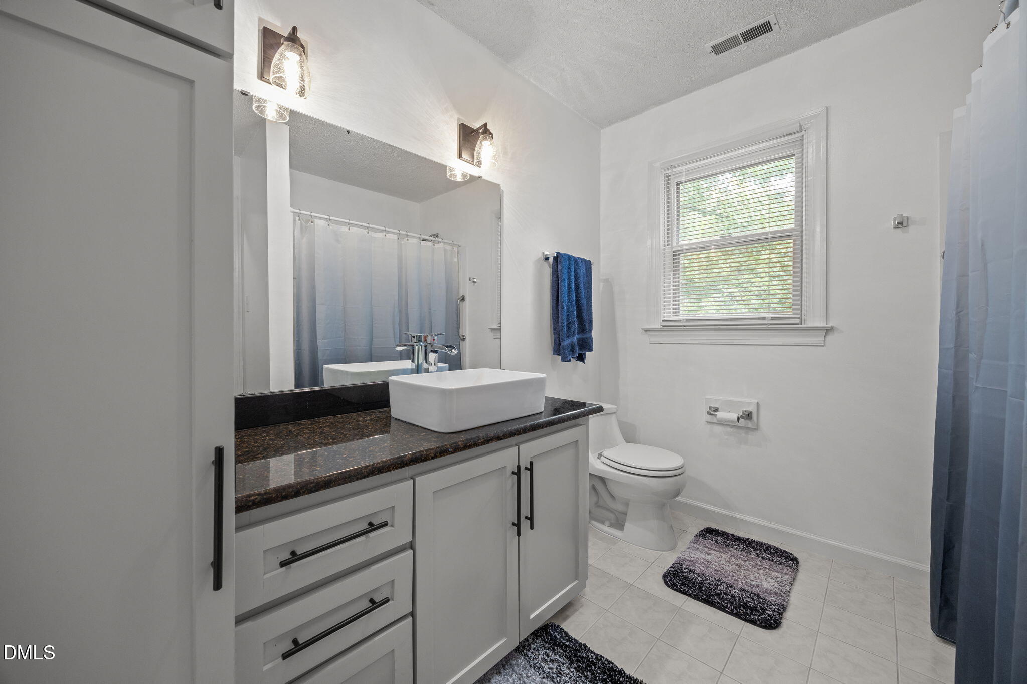 8641 Buffaloe Road Knightdale, NC 27545 - Photo 31 of 52 a bathroom with a granite countertop sink toilet and mirror