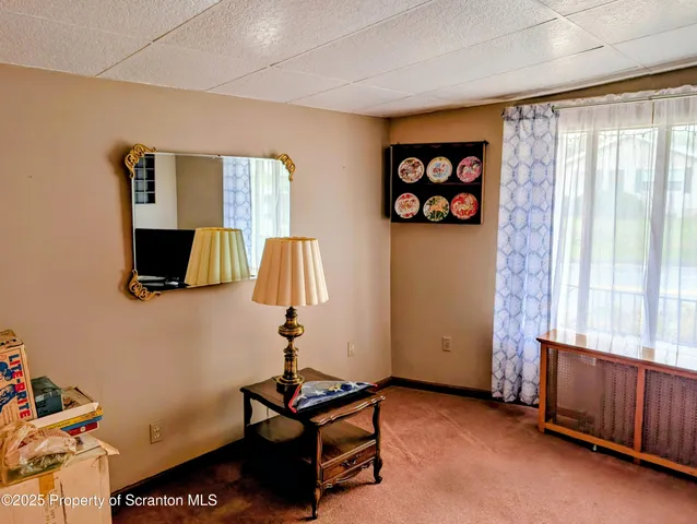 a living room with furniture a flat screen tv and a window