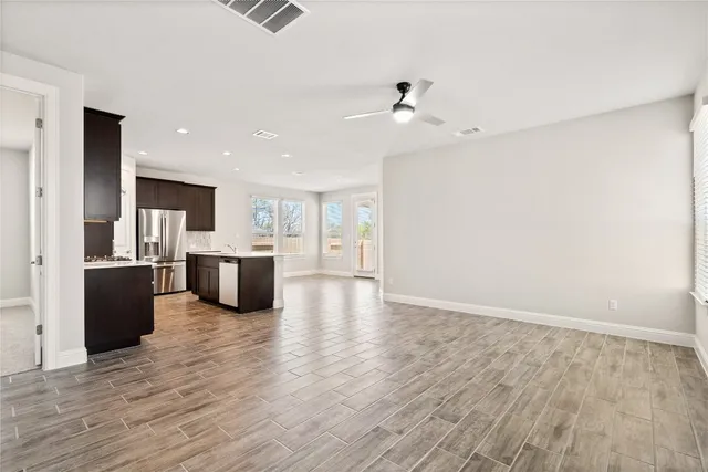 an empty room with windows and fan