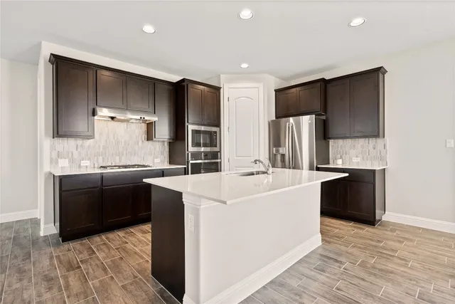 a view of kitchen with wooden floor electronic appliances and window
