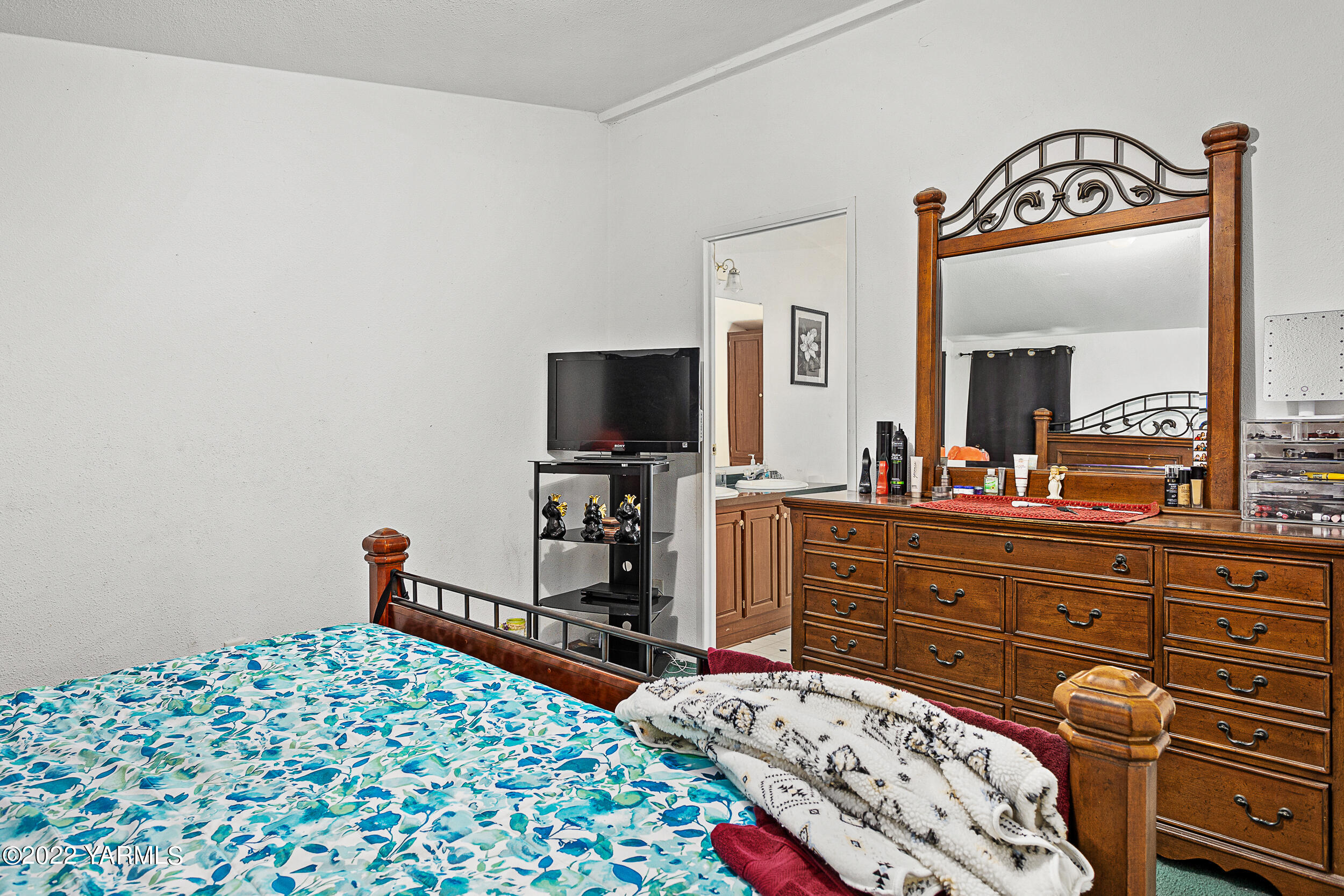 221 Rowberry Way Toppenish, WA 98948 - Photo 24 of 31 a bedroom with a bed and a flat tv screen on dresser