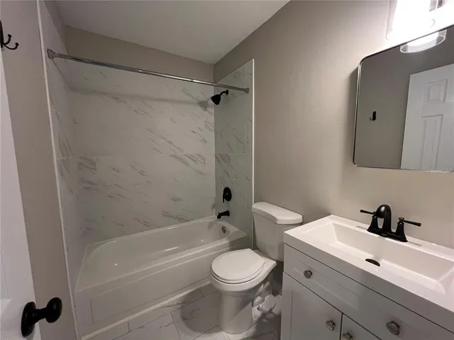 a bathroom with a granite countertop sink and white cabinets