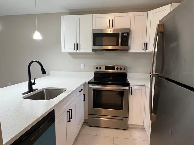 a kitchen with stainless steel appliances a refrigerator and a sink