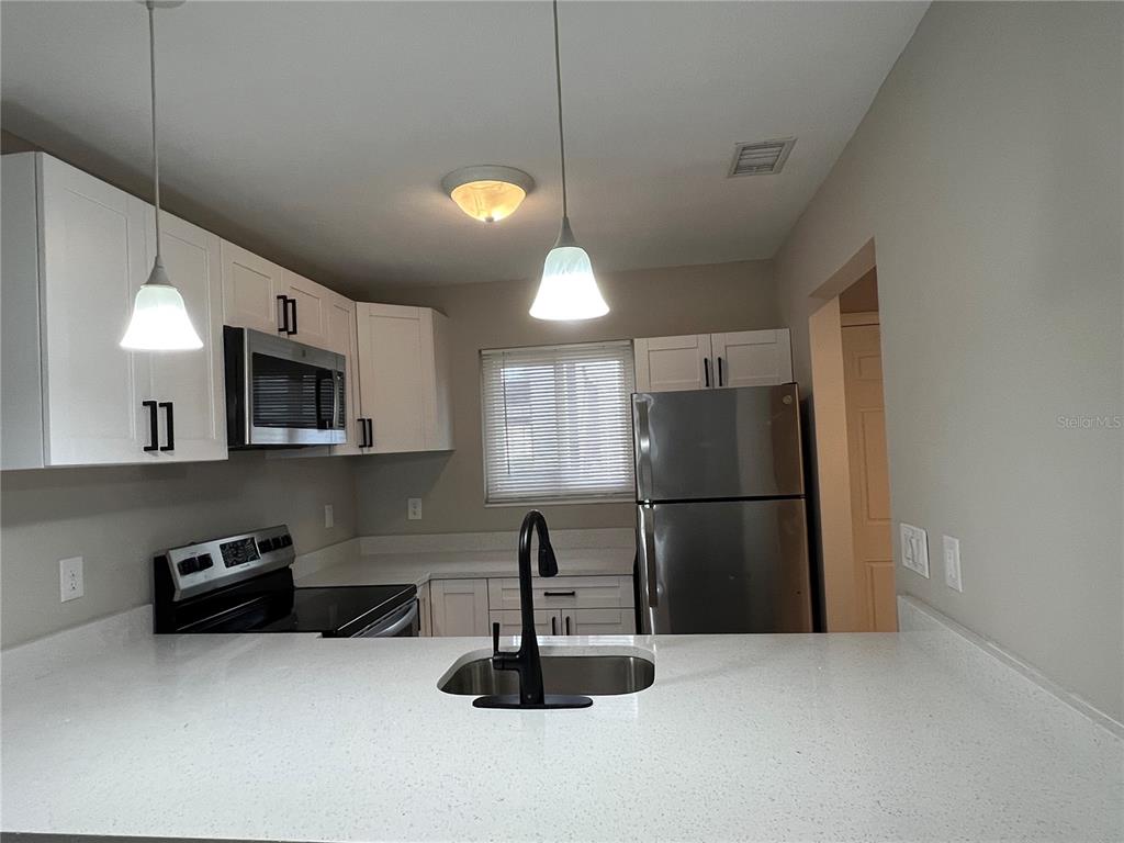 39132 County Road 54, Unit 2064 Zephyrhills, FL 33542 - Photo 4 of 20 a kitchen with stainless steel appliances a refrigerator and a sink