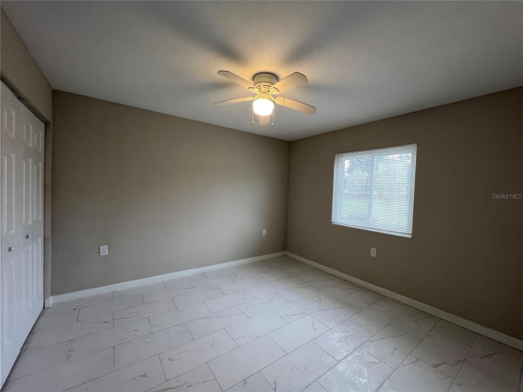 39132 County Road 54, Unit 2064 Zephyrhills, FL 33542 - Photo 7 of 20 a view of an empty room with window and chandelier fan