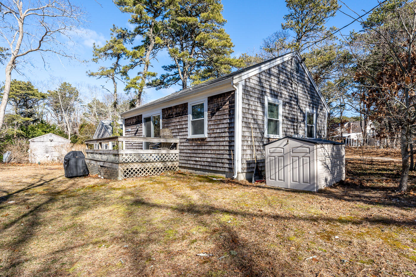 60 Long Avenue, Unit E Wellfleet, MA 02667 - Photo 16 of 22 a view of a house with a large tree and wooden fence