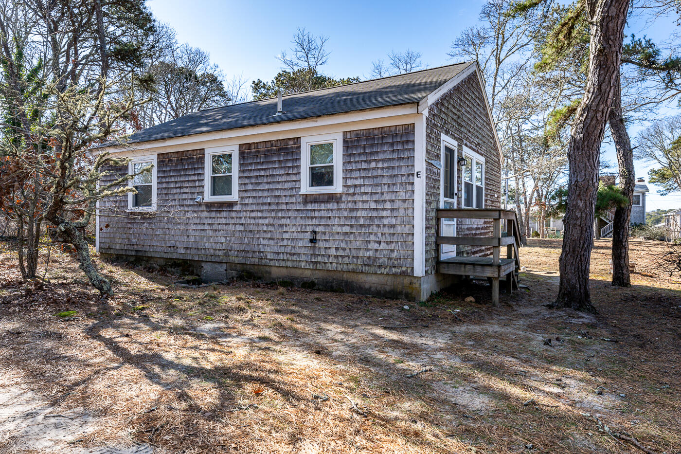 60 Long Avenue, Unit E Wellfleet, MA 02667 - Photo 22 of 22 a view of a house with a backyard and trees