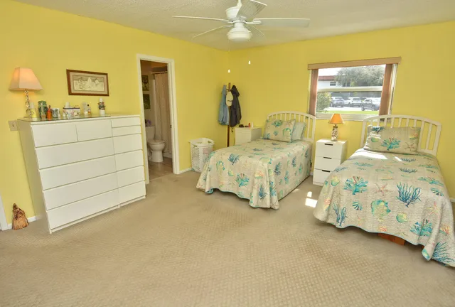 a spacious bedroom with two bed and a dresser