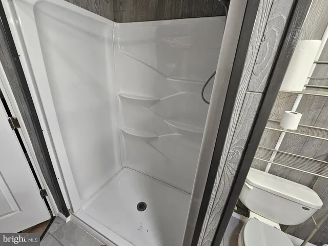 a bathroom with a glass door shower and toilet