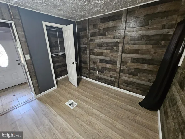 a view of empty room with wooden floor