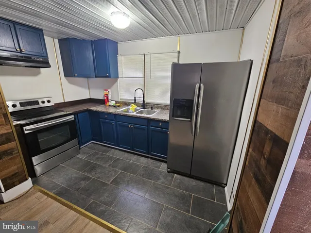 a kitchen with stainless steel appliances granite countertop a refrigerator stove and sink
