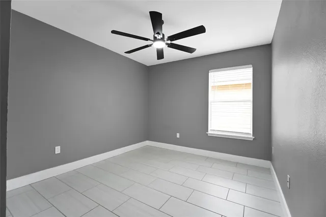 an empty room with a window and a fan