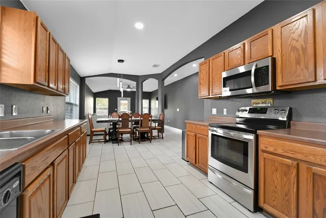 a kitchen with stainless steel appliances a stove sink microwave and cabinets
