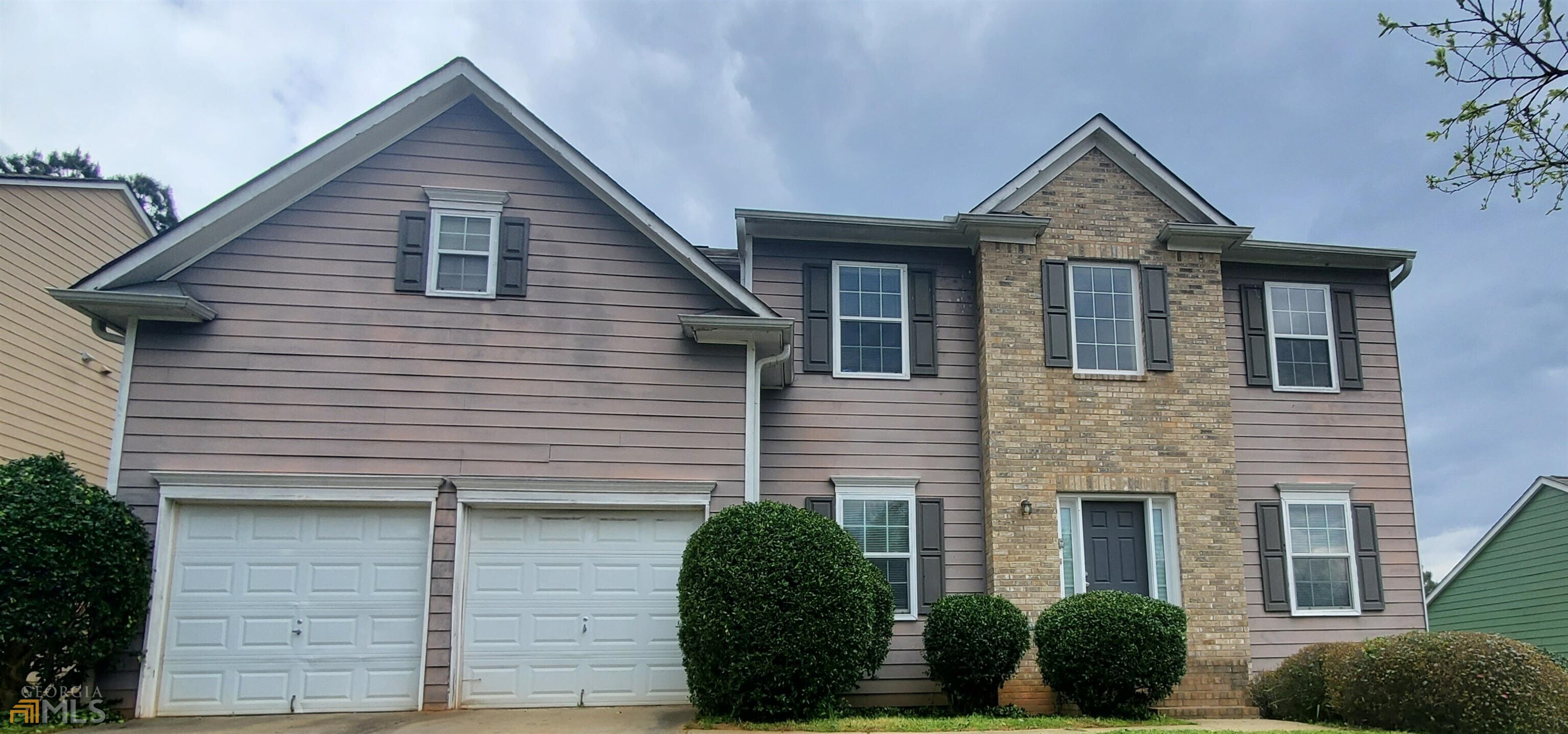 a front view of a house with plants