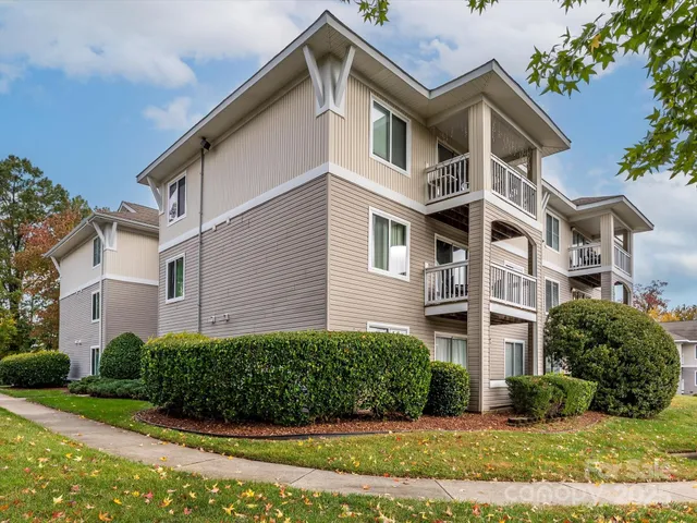 a view of a white building among the street with palm trees