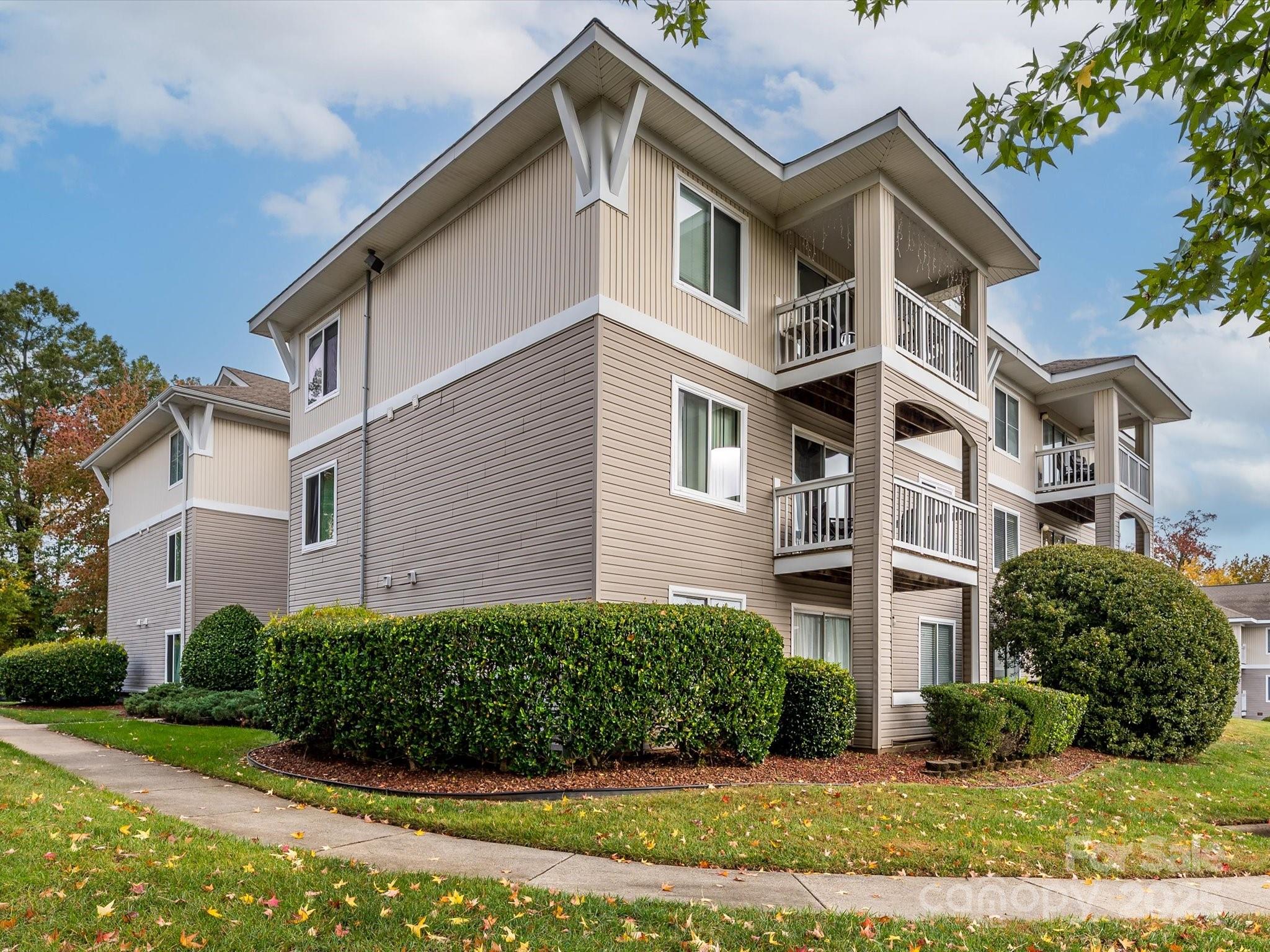 10005 Graduate Lane, Unit K Charlotte, NC 28262 - Photo 1 of 25 a view of a white building among the street with palm trees