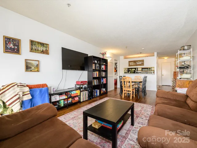 a living room with furniture a flat screen tv and a bookshelf