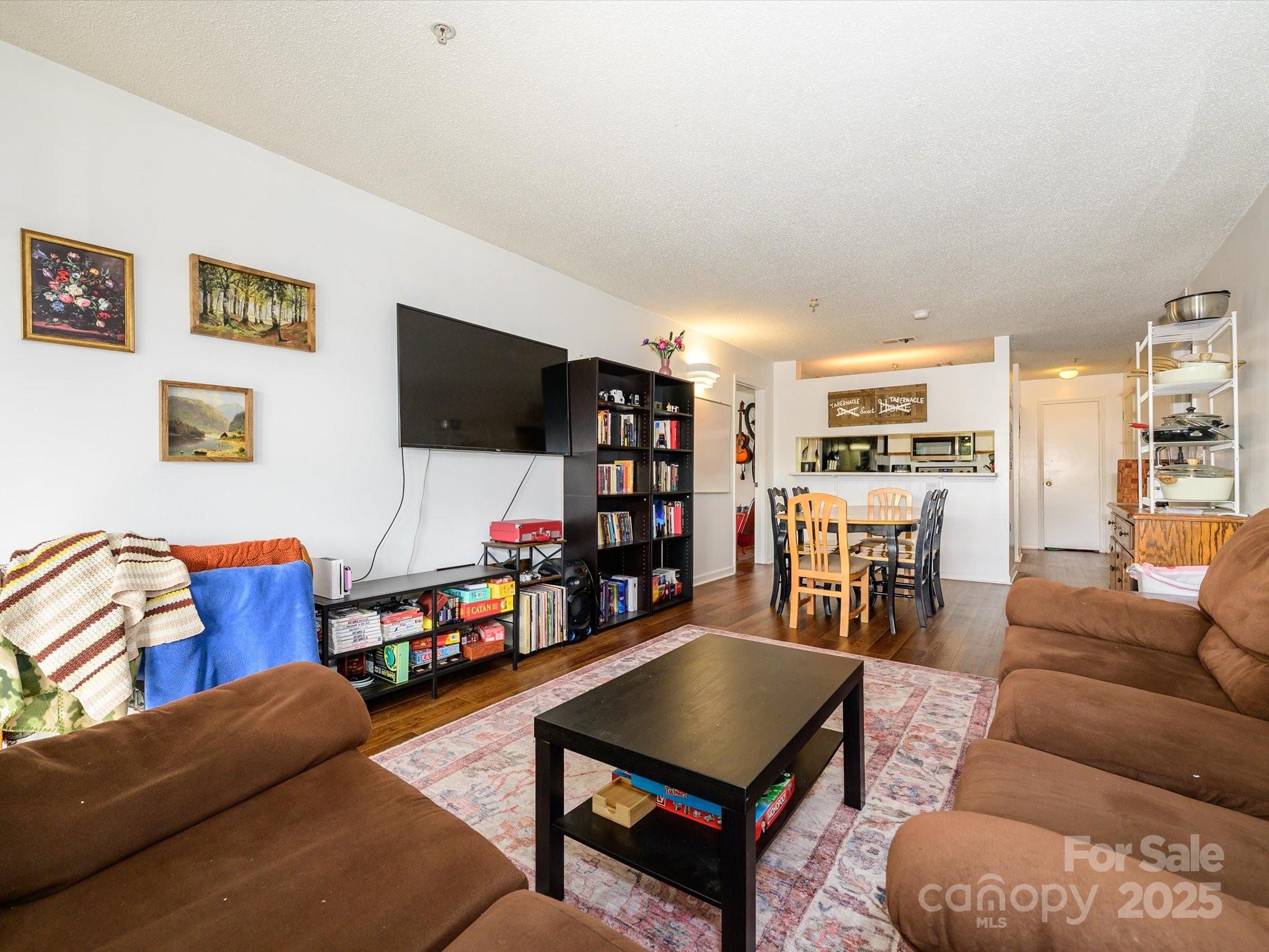 10005 Graduate Lane, Unit K Charlotte, NC 28262 - Photo 13 of 25 a living room with furniture a flat screen tv and a bookshelf