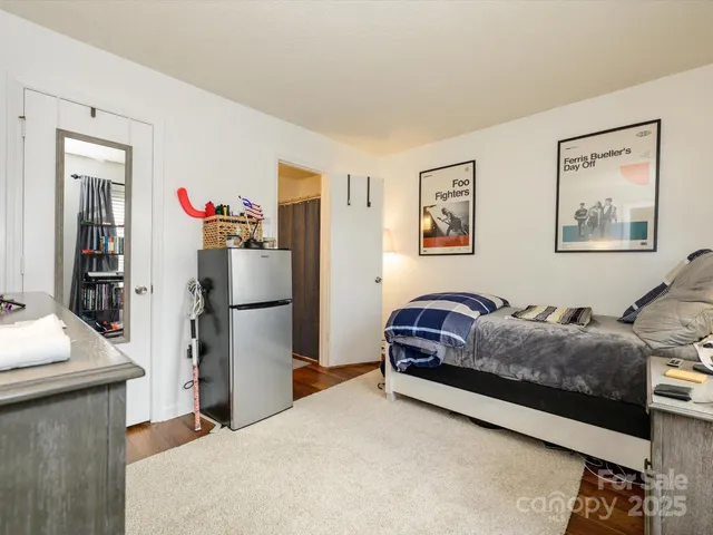 a living room with furniture and a refrigerator