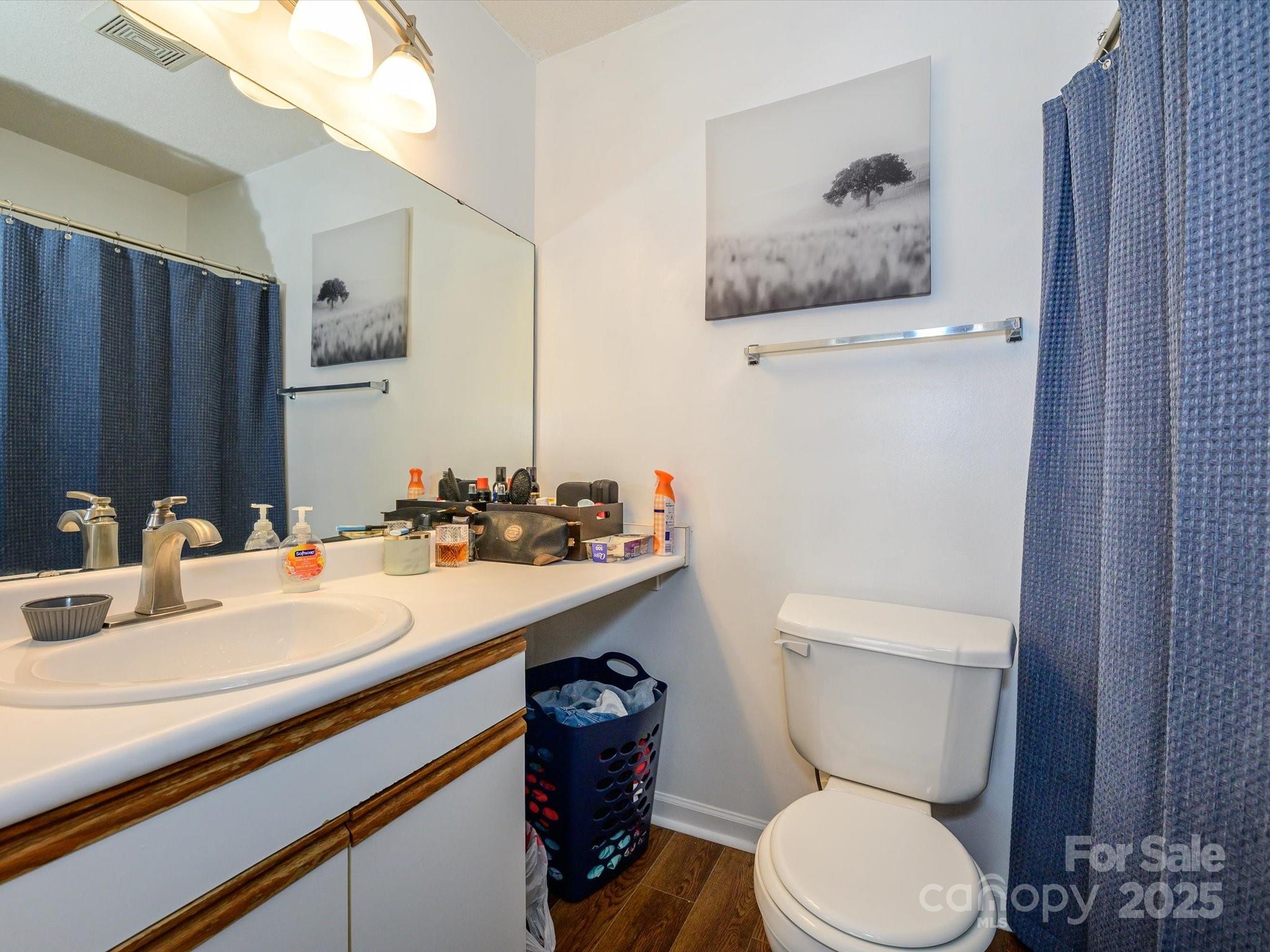 10005 Graduate Lane, Unit K Charlotte, NC 28262 - Photo 15 of 25 a bathroom with a toilet sink and mirror