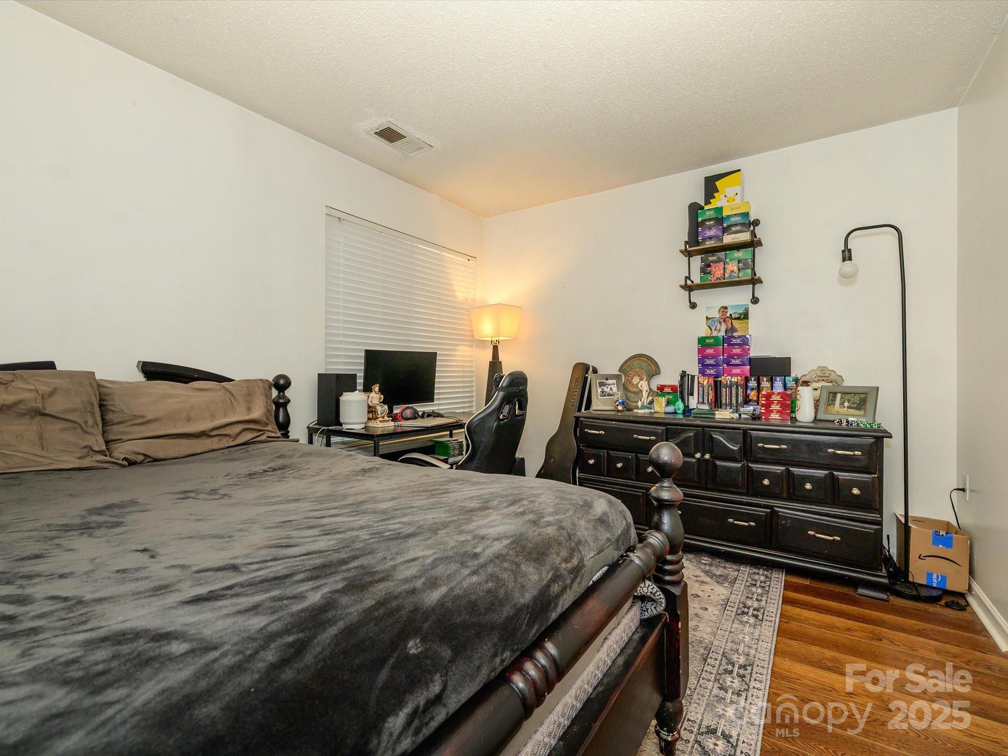 10005 Graduate Lane, Unit K Charlotte, NC 28262 - Photo 16 of 25 a bedroom with a bed and a flat screen tv