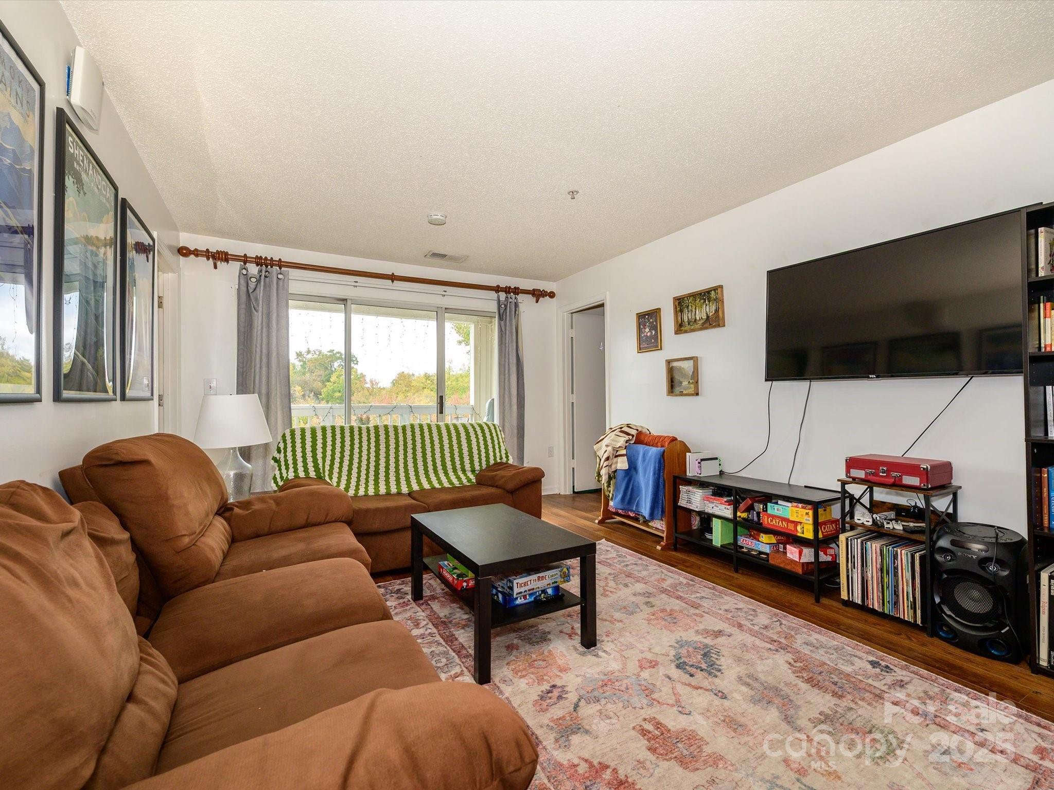 10005 Graduate Lane, Unit K Charlotte, NC 28262 - Photo 10 of 25 a living room with furniture and a flat screen tv