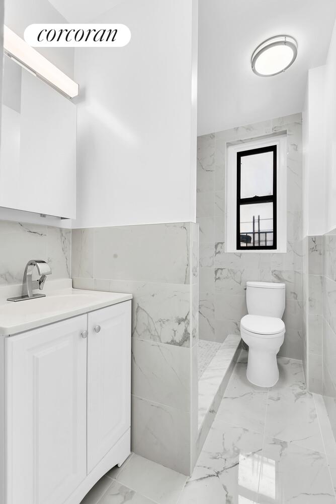 3245 Perry Avenue, Unit 4B Bronx, NY 10467 - Photo 7 of 8 a bathroom with a toilet sink and a shower