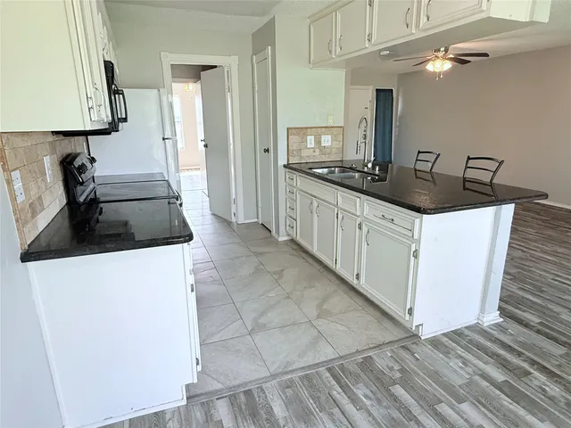 a kitchen with granite countertop a sink and cabinets
