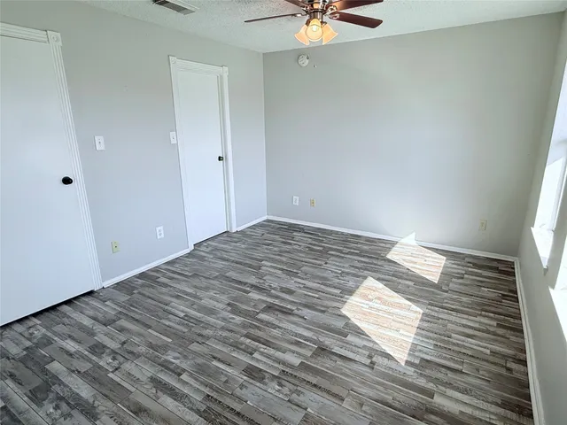 a view of a room with wooden floor and fan