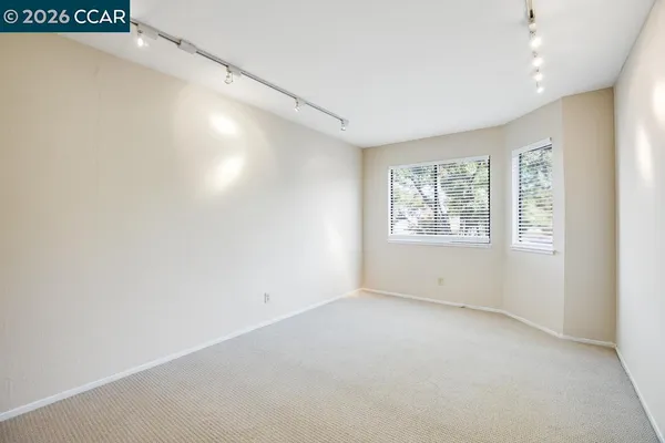 an empty room with windows and closet